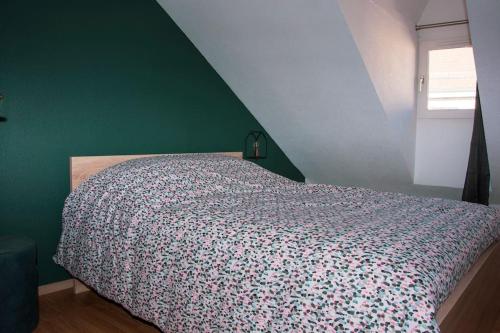 Ce lit se trouve dans une chambre dotée d'un mur vert. dans l'établissement T3 plein de charme au cœur de Montbéliard, à Montbéliard