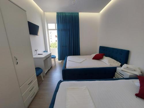 ein Hotelzimmer mit zwei Betten und einem Schreibtisch in der Unterkunft GRAND HOTEL eae in Durrës