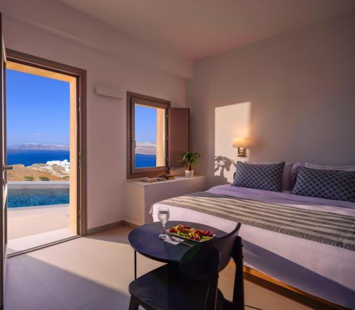 a bedroom with a bed and a table with a plate of food on it at Kalestesia Suites in Akrotiri