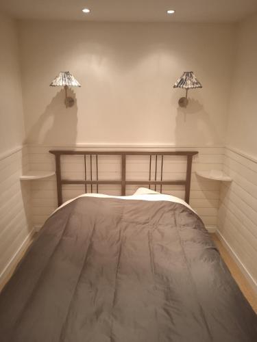 une chambre avec un lit et deux lampes au mur dans l'établissement appartement refait neuf meublé 2 pieces, à Rueil-Malmaison