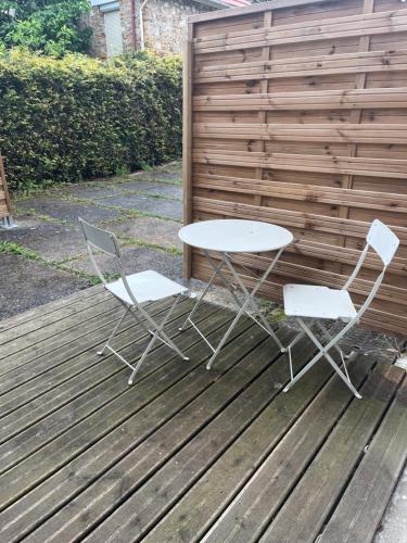 deux chaises et une table sur une terrasse en bois dans l'établissement appartement refait neuf meublé 2 pieces, à Rueil-Malmaison