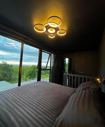 a bedroom with a bed with a ceiling fan and a window at Eco house 2 in Prestatyn