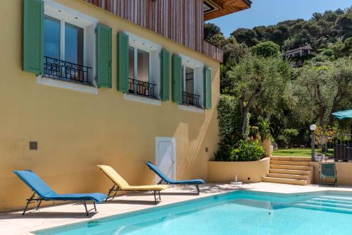 une maison avec deux chaises et une piscine dans l'établissement Villa Summertime, à Nice