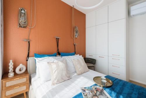 a bedroom with a bed with an orange wall at Sol Marina Resort Wyspa Sobieszewska I - LoftAffair Collection in Wiślinka