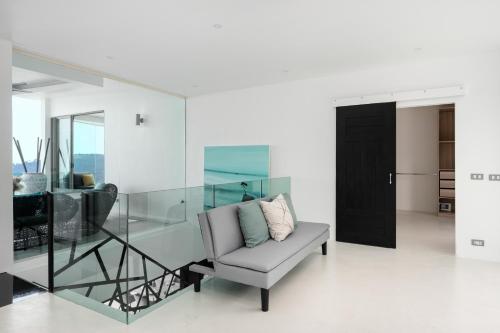 a living room with a glass table and a chair at Villa Best View Samui managed by Villa For You in Koh Samui 