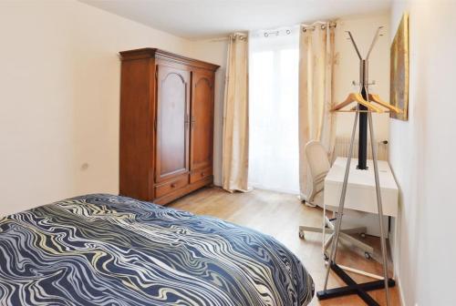une chambre avec un lit, une commode et un bureau dans l'établissement F2 proche gare - 5min RER Orly 15min, à Juvisy-sur-Orge