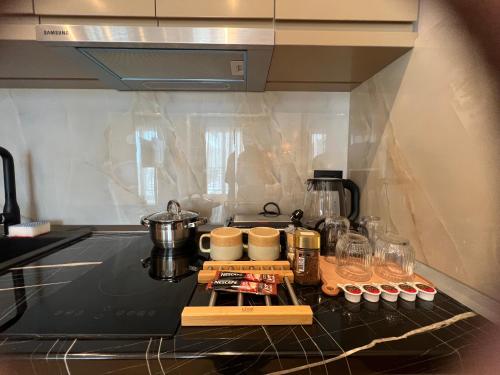 a kitchen with a counter top with a stove top oven at Coastline Luxury Apart Hotel in Golem