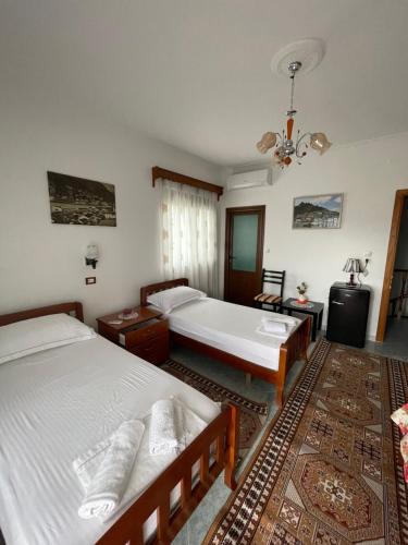 1 dormitorio con 2 camas y bañera. en Guest House Xhuljon en Berat
