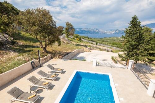a pool with chairs and a view of the water at Emerald Eco Villa in Novo Selo