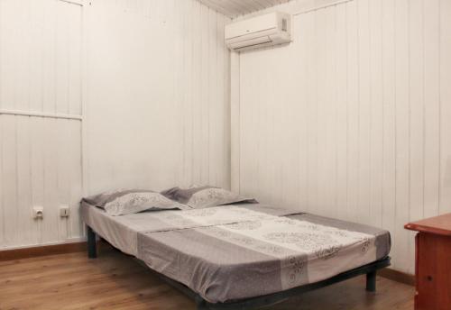 a bed in a room with a white wall at Maison de 2 chambres a Saint Gilles les Bains a 500 m de la plage avec terrasse amenagee et wifi in Saint-Gilles-les-Bains