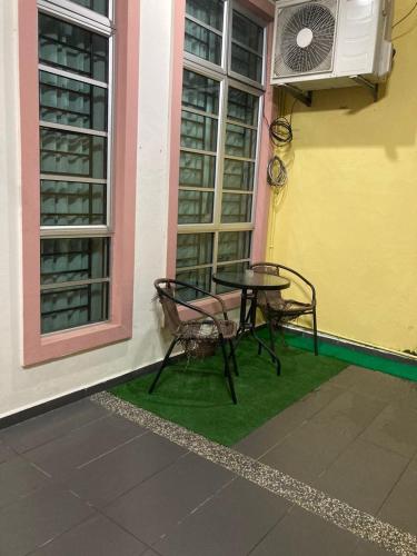 a table and chairs sitting next to a building at Ardhil Homestay Duyung in Melaka
