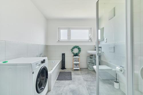 a white bathroom with a washing machine in it at Neubau Luxus Penthouse - Netflix - BBQ in Mannheim