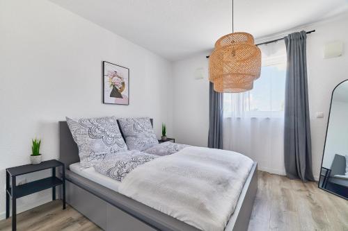 a bedroom with a bed and a pendant light at Neubau Luxus Penthouse - Netflix - BBQ in Mannheim
