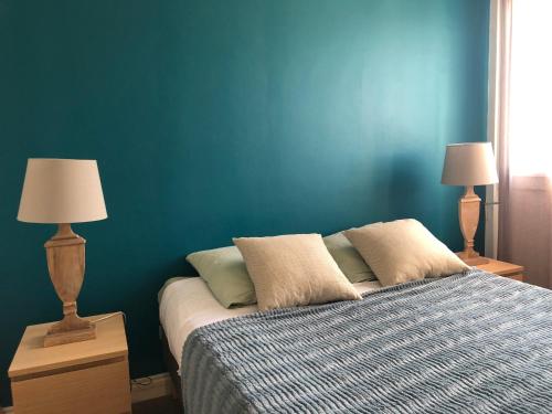 サントロペにあるappartement vue merのベッドルーム1室(青い壁のベッド1台、ランプ2つ付)