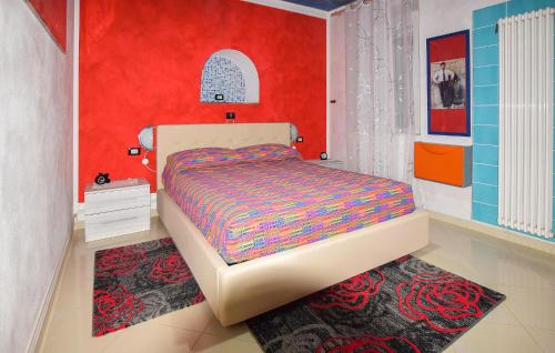 um quarto com uma cama e uma parede vermelha em 3 Bedroom Stunning Apartment In Roccaspinalveti em Villa Santa Maria