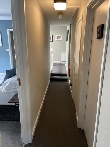 um corredor que leva a um quarto com uma cama em Skyline Guesthouse em Newquay