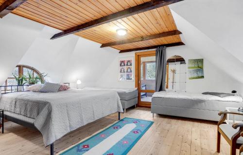 a bedroom with two beds and a rug at Mormors Hus in Mariager