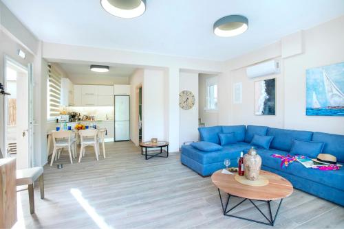 a living room with a blue couch and a table at Erato by Vintage Travel in Tsoukaladhes