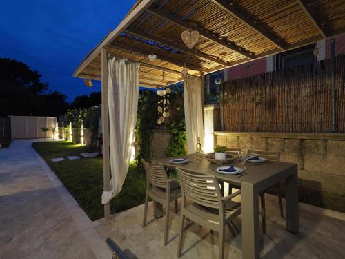 a dining table and chairs under a pergola at Erato by Vintage Travel in Tsoukaladhes