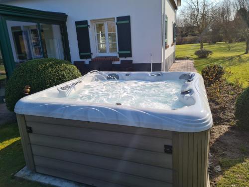 a hot tub in the yard of a house at Mil Roses en Baie in Saint-Quentin-en-Tourmont
