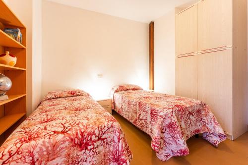 a bedroom with two beds and a book shelf at Villa Agnesina in Solanas