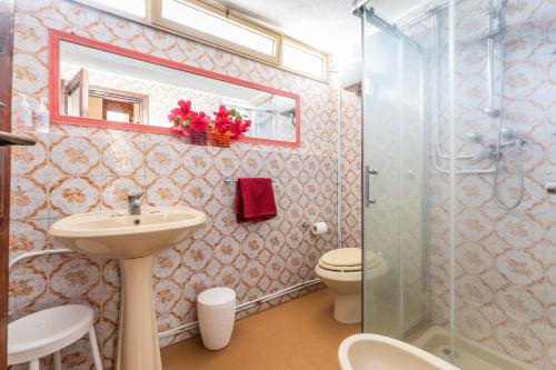 a bathroom with a toilet and a sink and a shower at Villa Agnesina in Solanas