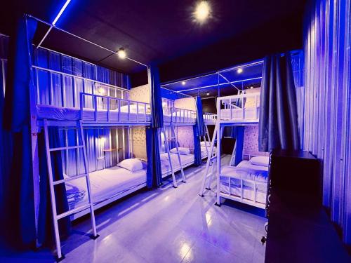 two bunk beds in a room with blue lights at The Lab Sleep Hostel in Chiang Rai