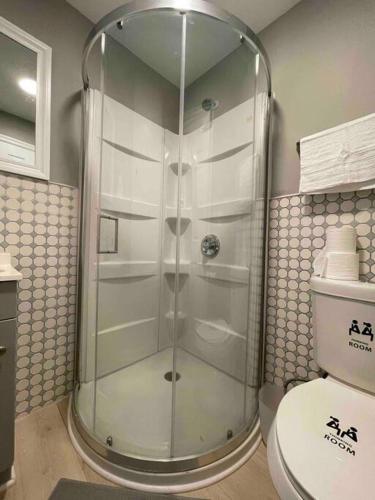 a glass shower in a bathroom with a toilet at Discover Charm City from a Cozy Retreat in Baltimore