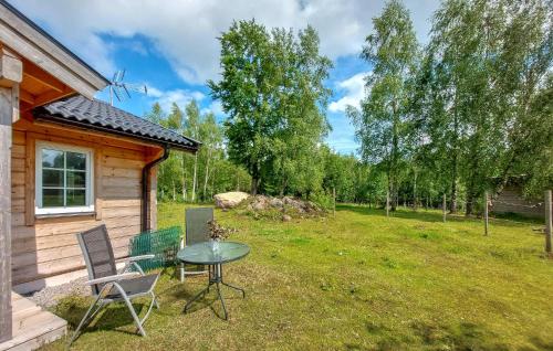 a small cabin with a table and chairs in the yard at Nice Home In Munka Ljungby in Munka-Ljungby