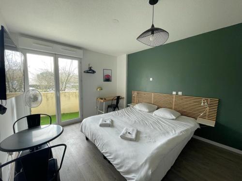 una camera da letto con un grande letto con una parete verde di Bel appartement design tout confort (Parking Gratuit) à 10 minutes de Bordeaux a Cenon