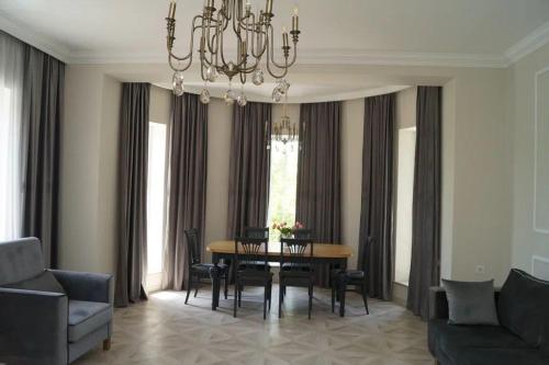 a dining room with a table and chairs and a chandelier at New house in Jrvezh in Yerevan