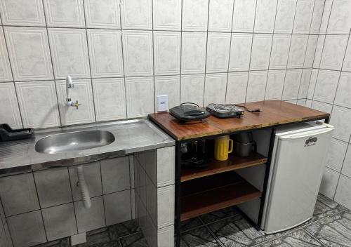 uma pequena cozinha com um lavatório e um frigorífico em Residencial Margarida APART 4 em Presidente Figueiredo