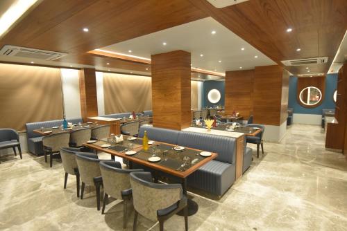 ソムナスにあるKings Kraft Tremezzo Inn, Somnathの部屋にテーブルと椅子があるレストラン