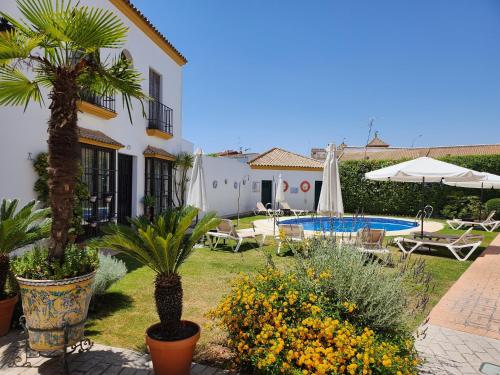 een tuin met een zwembad en een huis bij Hacienda Olontigi in Aznalcázar