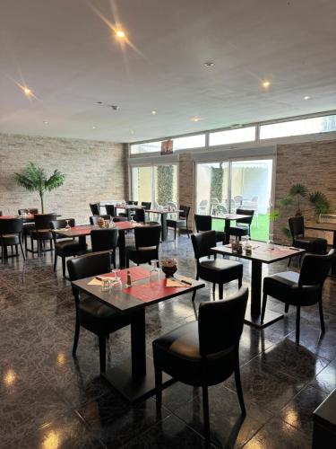 un restaurant avec des tables et des chaises dans une salle dans l'établissement La Cascade, à Onet le Château