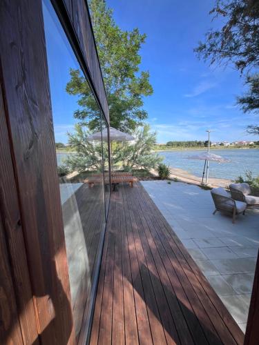 una porta a vetri di una casa con vista sull'acqua di 10gardens Premium Mobile Homes with private jacuzzi & sauna by OIKO Collection a Privlaka (Brevilacqua)