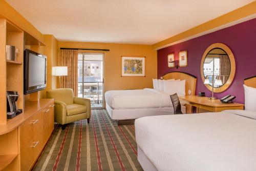a hotel room with two beds and a television at Pier 5 Hotel Baltimore in Baltimore