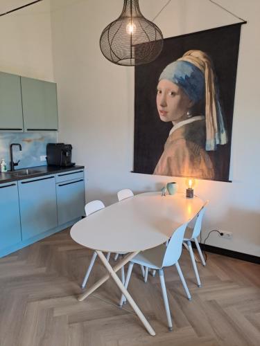 a kitchen with a table and a painting of a woman at De Platwever 3B in Zelhem
