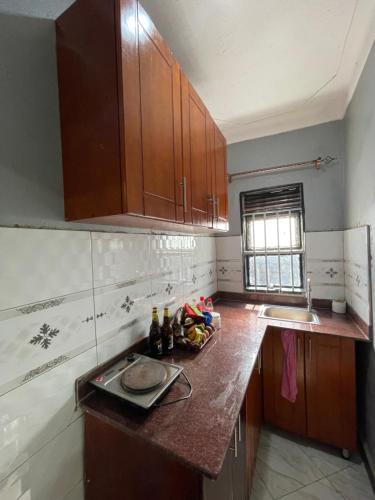 a kitchen with wooden cabinets and a counter top at Urban Hues Holiday Home in Kampala