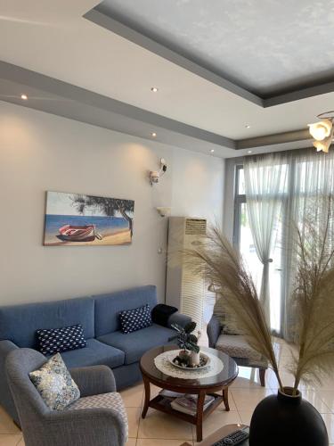 a living room with a blue couch and a table at Isidora Hotel in Agia Marina Aegina