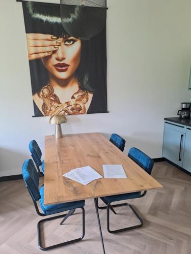 una mesa de madera con sillas y una foto de una mujer en De Platwever 3C en Zelhem