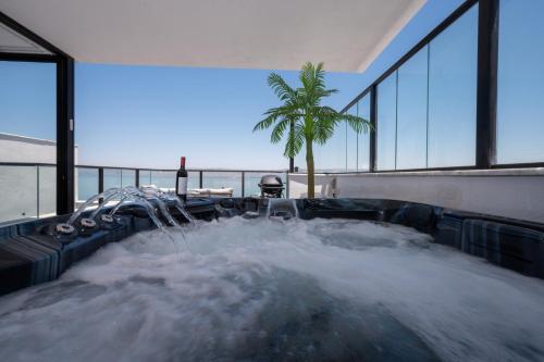a hot tub with water in a building with a palm tree at לוי-קיישן מגוון דירות גן ופנטהאוזים וסוויטות נוף ברחוב הצנחנים in Tiberias