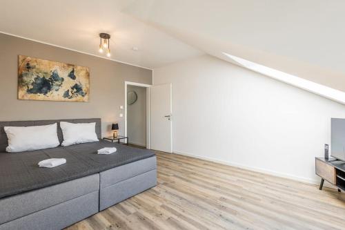 a living room with a bed and a television at Sky Penthouse 07 I Aufzug I TV I Terrasse I BBQ in Hamm