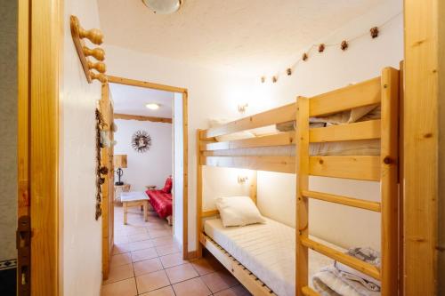 une chambre avec deux lits superposés et un miroir dans l'établissement Myosotis, à Valloire