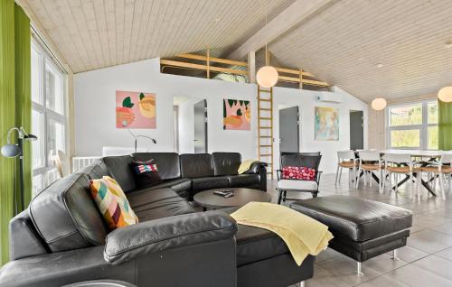 a living room with a black leather couch and a table at Beautiful Home In Ebeltoft With Wifi in Ebeltoft