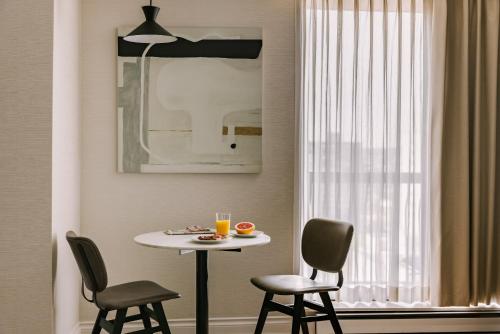 - une table et des chaises dans une chambre avec fenêtre dans l'établissement Sonder The Sunset, à Vancouver