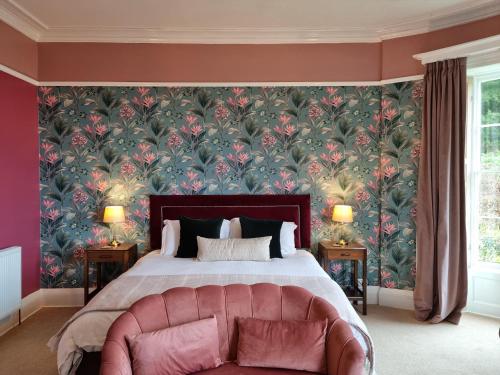 a bedroom with a large bed with a pink couch at Laston House in Ilfracombe