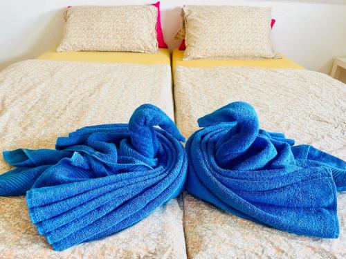 Un par de camas con mantas azules. en Tarida`Guesthouse en Brunswick