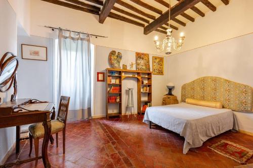 Un dormitorio con una cama, un escritorio y un piano. en Villa Campo di Fiore, en Arezzo