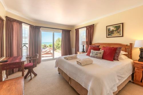 Un dormitorio con una cama y un escritorio y una ventana. en Main Beach Proximity, en Cape St. Francis